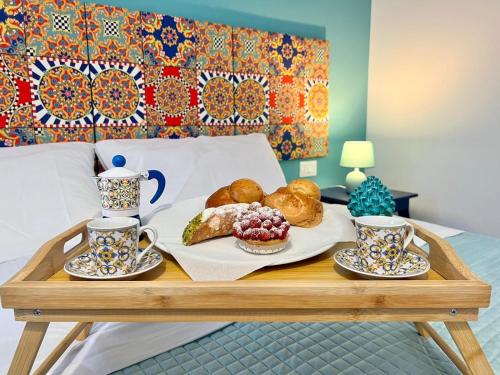 a tray of breakfast foods on a bed with two cups at Sicily in Love - Rooms and Apartment - Pedara Catania Etna in Pedara