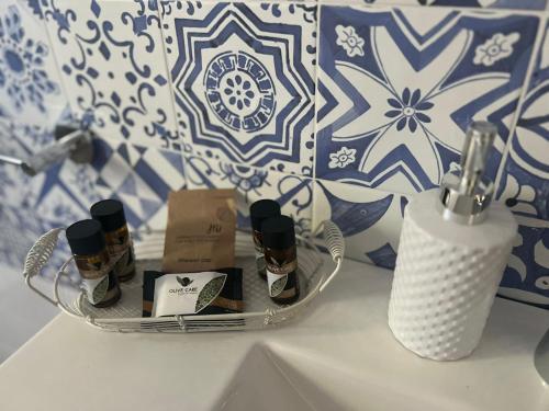 a bathroom counter with a shelf with bottles of perfume at Sicily in Love - Rooms and Apartment - Pedara Catania Etna in Pedara