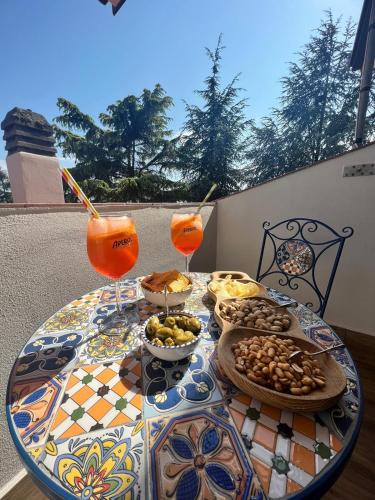 a table with plates of food and drinks on it at Sicily in Love - Rooms and Apartment - Pedara Catania Etna in Pedara