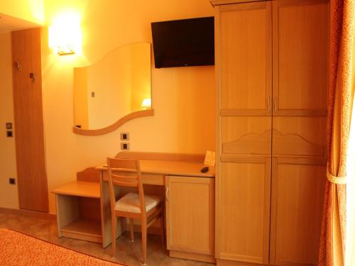 a room with a desk with a chair and a mirror at Blu Tropical Resort in Zambrone