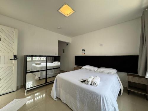 a bedroom with a bed with two towels on it at John- R Apart-hotel Curitiba Jardim Botânico in Curitiba