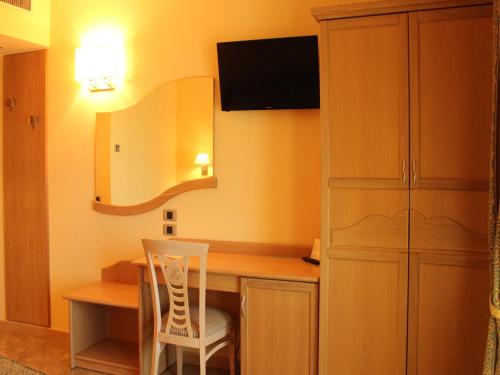 a room with a desk with a chair and a mirror at Blu Tropical Resort in Zambrone