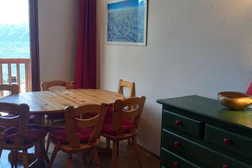 une table à manger avec des chaises et une commode verte dans l'établissement Paradiski proche des pistes vallandry, à Landry
