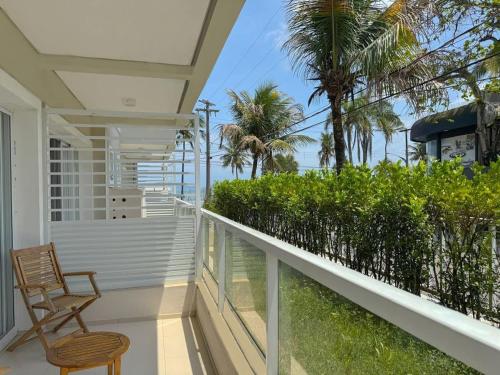 a balcony with a chair and a view of the ocean at The Falls Hotel in Guarujá