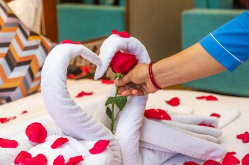 a person making a rose out of towels at Dream International Hotel in Lumbini