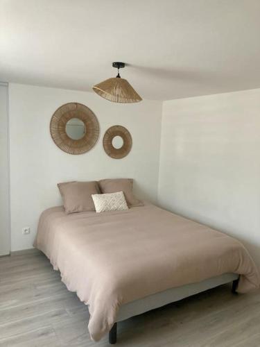 une chambre blanche avec un lit et un miroir dans l'établissement Villa Inès, à Langres