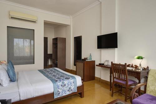 a bedroom with a bed and a desk and a chair at Anandam - A Luxury Resort in Udaipur in Udaipur