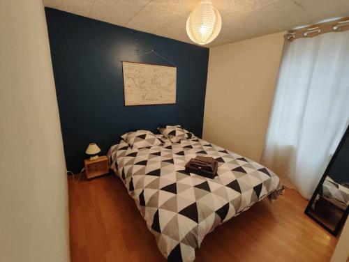 une chambre avec un lit avec une couette noire et blanche dans l'établissement Appartement avec terrasse, à Terrasson