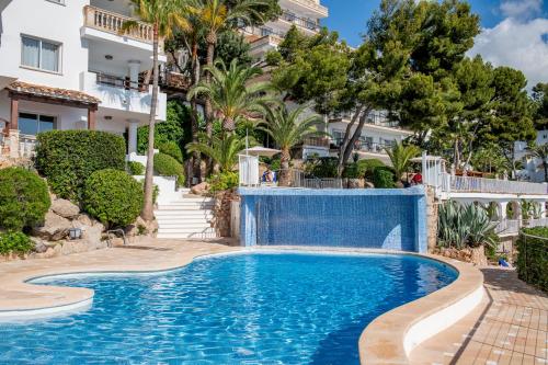 a swimming pool in front of a building with trees at Hotel ROC Illetas & SPA in Illetas