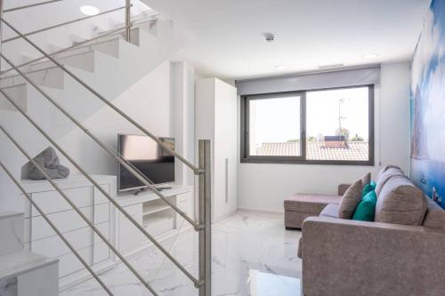 a living room with a staircase and a couch at Apartamentos Rosa de Abril in Teià