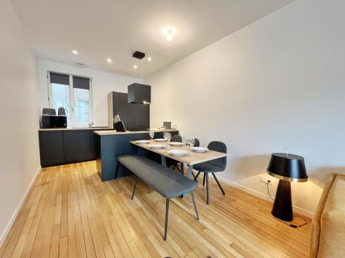 une salle à manger avec une table et des chaises et une cuisine dans l'établissement Le Albert Deauville, à Deauville