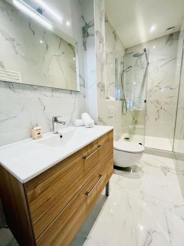 une salle de bain avec un lavabo et des toilettes dans l'établissement Le Albert Deauville, à Deauville