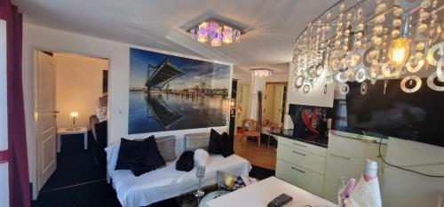 a living room with a white couch and a chandelier at Auf dem alten Deich in Sande
