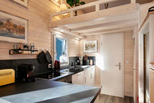 a kitchen with wooden walls and a counter top at Tiny House Nr 3 in Schwielowsee