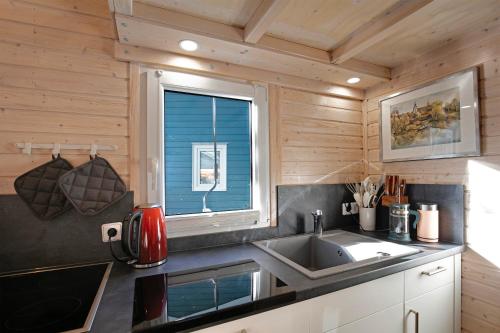 a kitchen with a sink and a window at Tiny House Nr 3 in Schwielowsee