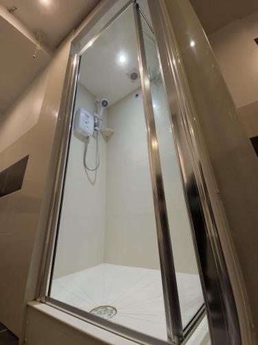 a shower with a glass door in a bathroom at Belford Hostel in Edinburgh