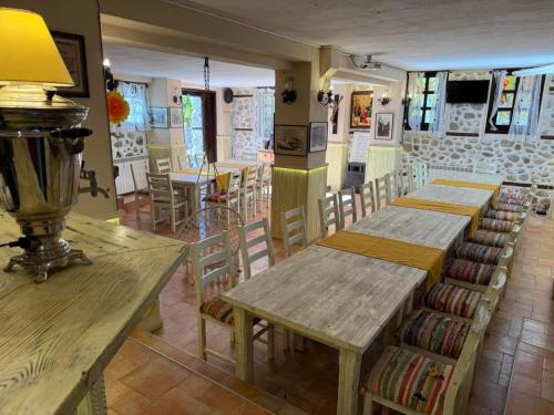 a restaurant with wooden tables and chairs in a room at Villa Melnik SPA Residence with Hot Pool by BookVillaBG in Melnik
