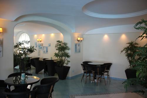 a dining room with tables and chairs and plants at Hotel Terme Park Imperial in Ischia