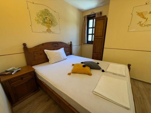 a bedroom with a bed with a stuffed animal on it at Villa Melnik SPA Residence with Hot Pool by BookVillaBG in Melnik