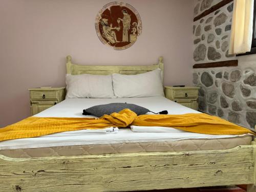 a bed with a yellow blanket on top of it at Villa Melnik SPA Residence with Hot Pool by BookVillaBG in Melnik