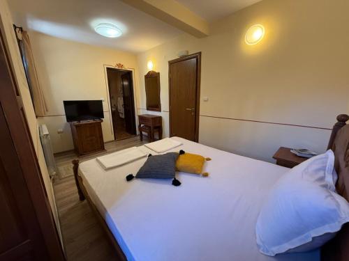 a bedroom with a white bed with two pillows on it at Villa Melnik SPA Residence with Hot Pool by BookVillaBG in Melnik