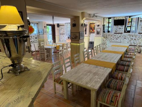a restaurant with wooden tables and chairs in a room at Villa Melnik SPA Residence with Hot Pool by BookVillaBG in Melnik