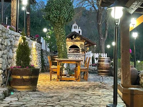 a stone patio with a table and a fireplace at Villa Melnik SPA Residence with Hot Pool by BookVillaBG in Melnik