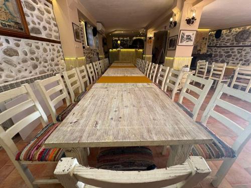 a long table in a restaurant with white chairs at Villa Melnik SPA Residence with Hot Pool by BookVillaBG in Melnik