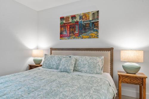 a bedroom with a bed with two lamps and a painting on the wall at 15 City View Santa Monica in Los Angeles