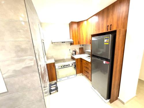 a small kitchen with a sink and a refrigerator at Luxury 2-bedroom- Sarai Compound in Cairo
