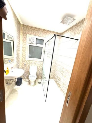 a bathroom with a toilet and a sink at Luxury 2-bedroom- Sarai Compound in Cairo