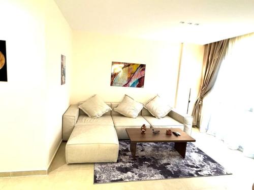 a living room with a couch and a coffee table at Luxury 2-bedroom- Sarai Compound in Cairo