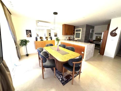 a kitchen and dining room with a wooden table and chairs at Luxury 2-bedroom- Sarai Compound in Cairo