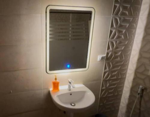 a bathroom with a sink and a window on the wall at Luxury 2-bedroom- Sarai Compound in Cairo