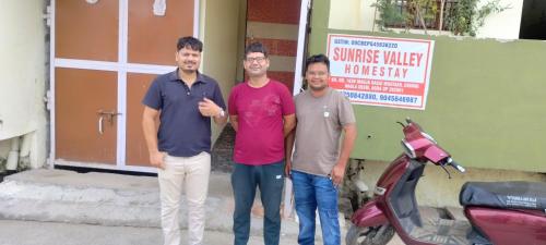 three men are standing in front of a motorcycle at Sunrise Homestay Agra Near Taj Mahal in Agra