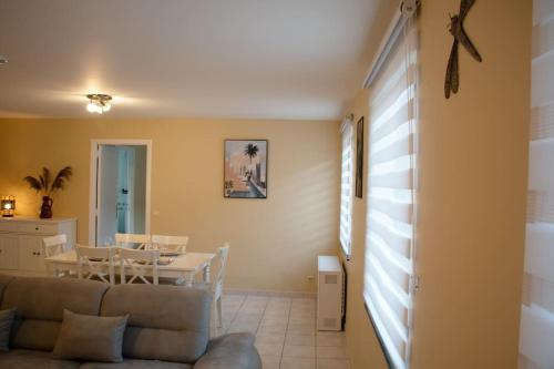 a living room with a couch and a table at Séjour en bord de Meuse avec garage in Dinant