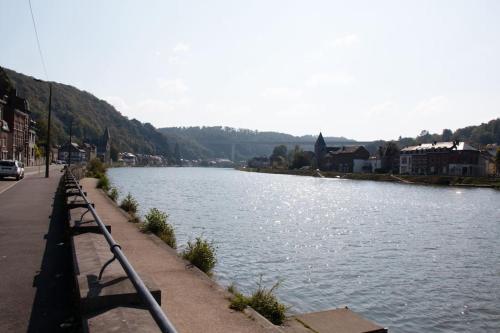 a body of water next to a road and a street at Séjour en bord de Meuse avec garage in Dinant