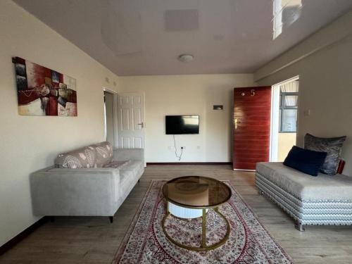 a living room with a couch and a table at Modern Downtown Escape in Gaborone