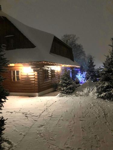 a house covered in snow at night with lights at Liptovská Drevenica in Liptovský Mikuláš