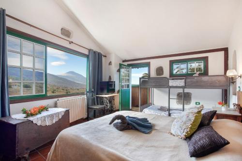 a bedroom with a large bed with a large window at Casa rural suerteluna in La Matanza de Acentejo