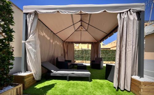 a gazebo with a couch and chairs on grass at Civico 16 in Nettuno