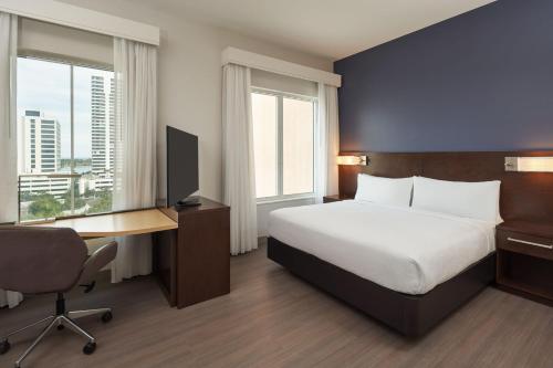 a hotel room with a bed and a desk with a computer at Residence Inn by Marriott West Palm Beach Downtown in West Palm Beach