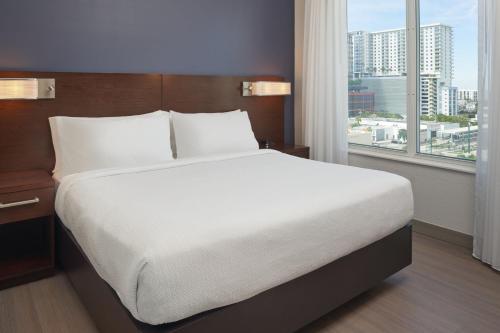a large bed in a hotel room with a large window at Residence Inn by Marriott West Palm Beach Downtown in West Palm Beach