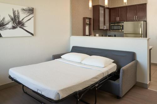 a bed with two pillows on it in a room at Residence Inn by Marriott West Palm Beach Downtown in West Palm Beach