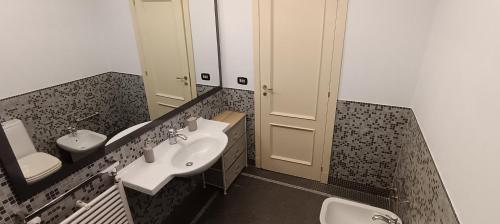 a bathroom with a sink and a toilet and a mirror at Pirandello Apartment Acitrezza in Aci Castello