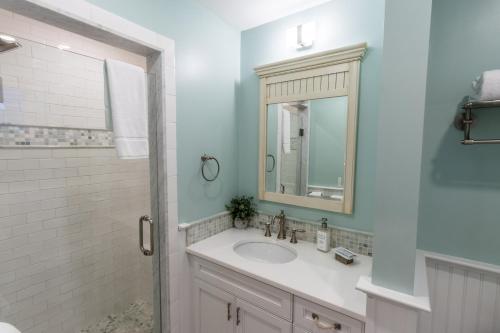 a bathroom with a sink and a mirror and a shower at The Newport Lofts - 548 Thames Street in Newport