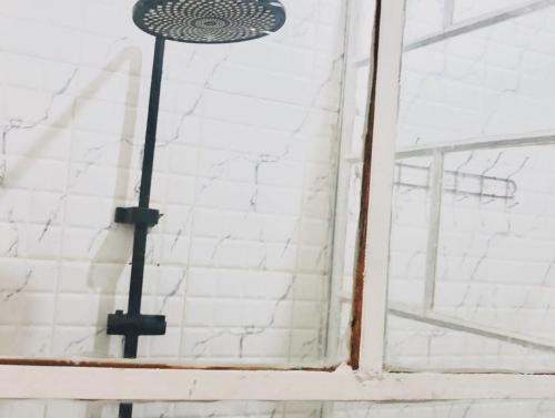 a shower in a bathroom with a window at SAISH Stay in Ruhengeri