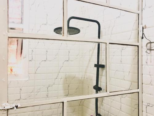 a glass shower door with a sink in a bathroom at SAISH Stay in Ruhengeri