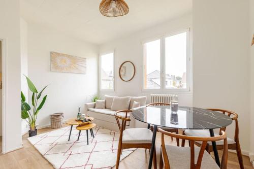 un salon avec une table, des chaises et un canapé dans l'établissement Le Gambetta Rouen, à Saint-Étienne-du-Rouvray