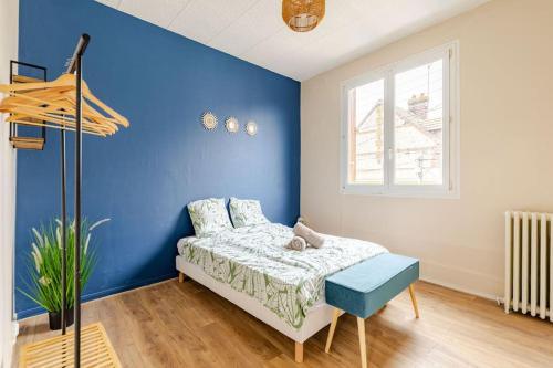 Cette chambre bleue comprend un lit et un mur bleu. dans l'établissement Le Gambetta Rouen, à Saint-Étienne-du-Rouvray